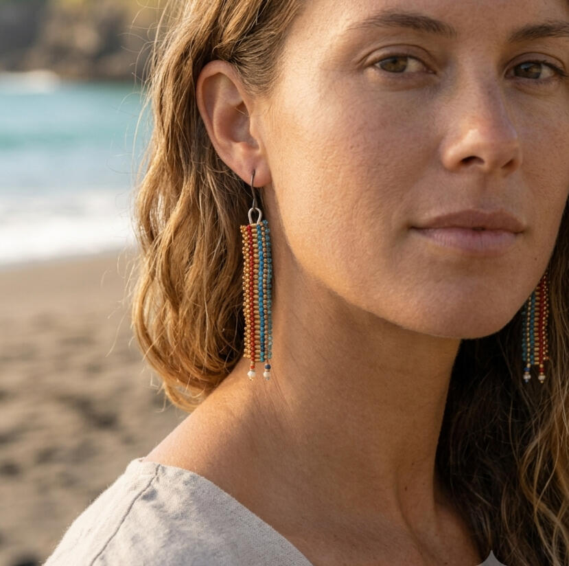 Beaded drop earrings worn by the sea